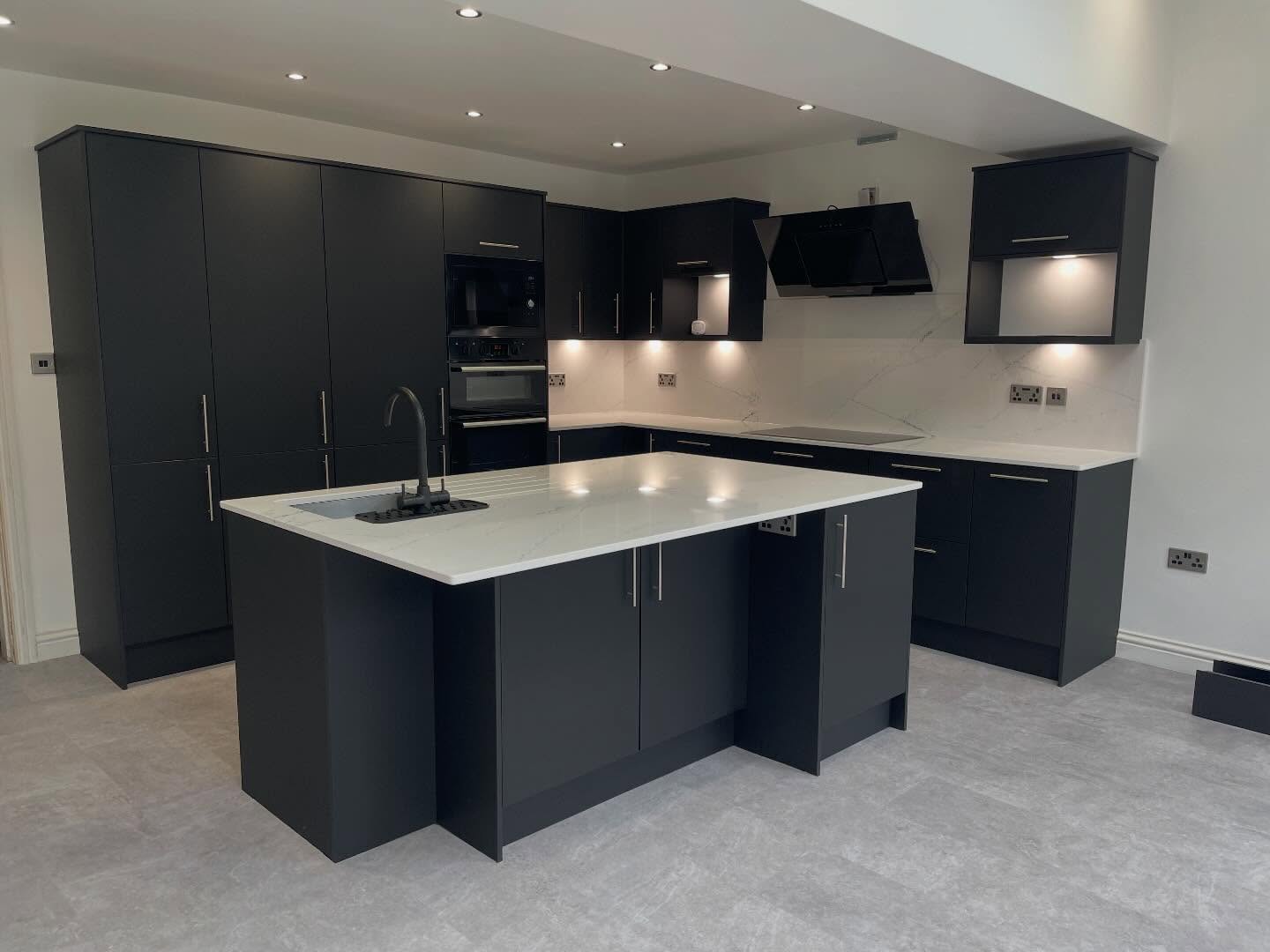 Matt black fitted kitchen with quartz worktop and island